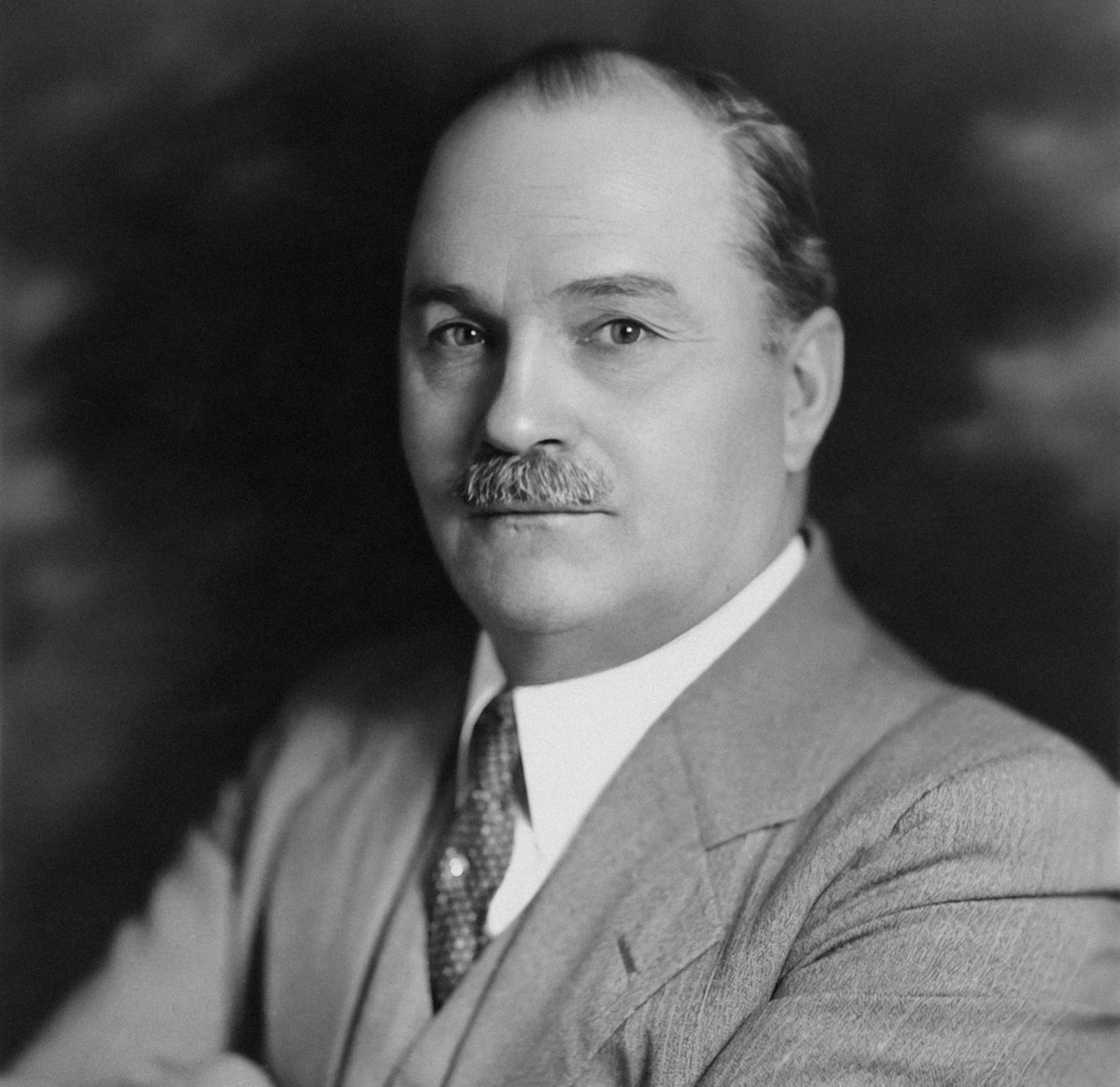 a black and white photo of a man with a mustache