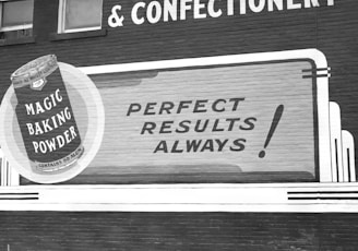 a black and white photo of a sign on the side of a building