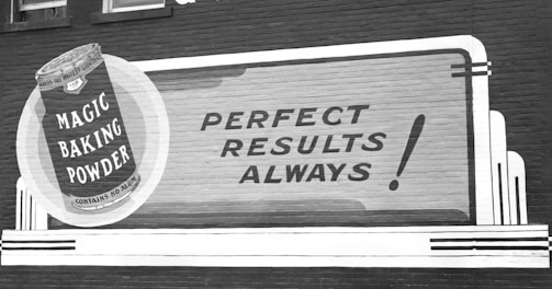 a black and white photo of a sign on the side of a building