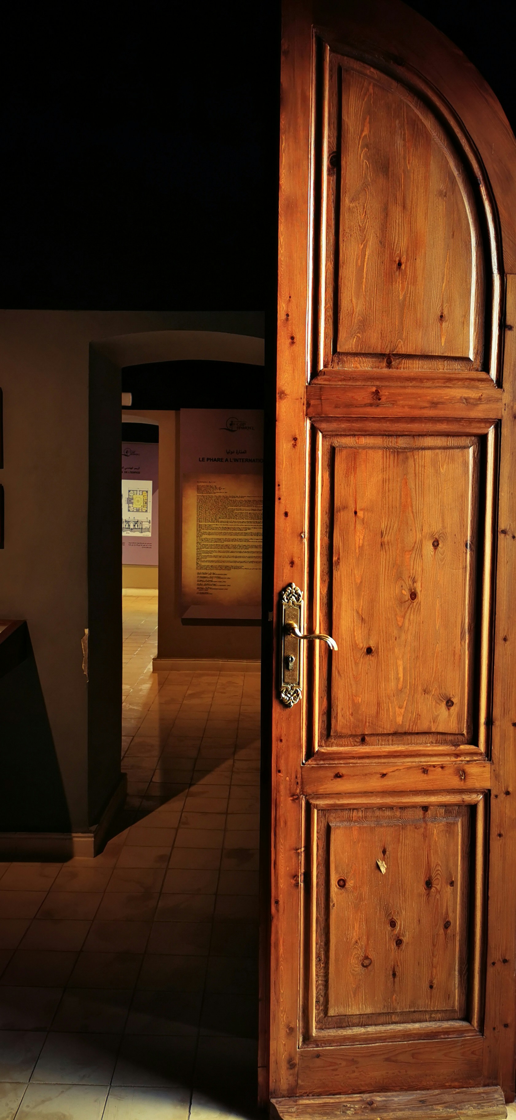 a wooden door is open on a tiled floor