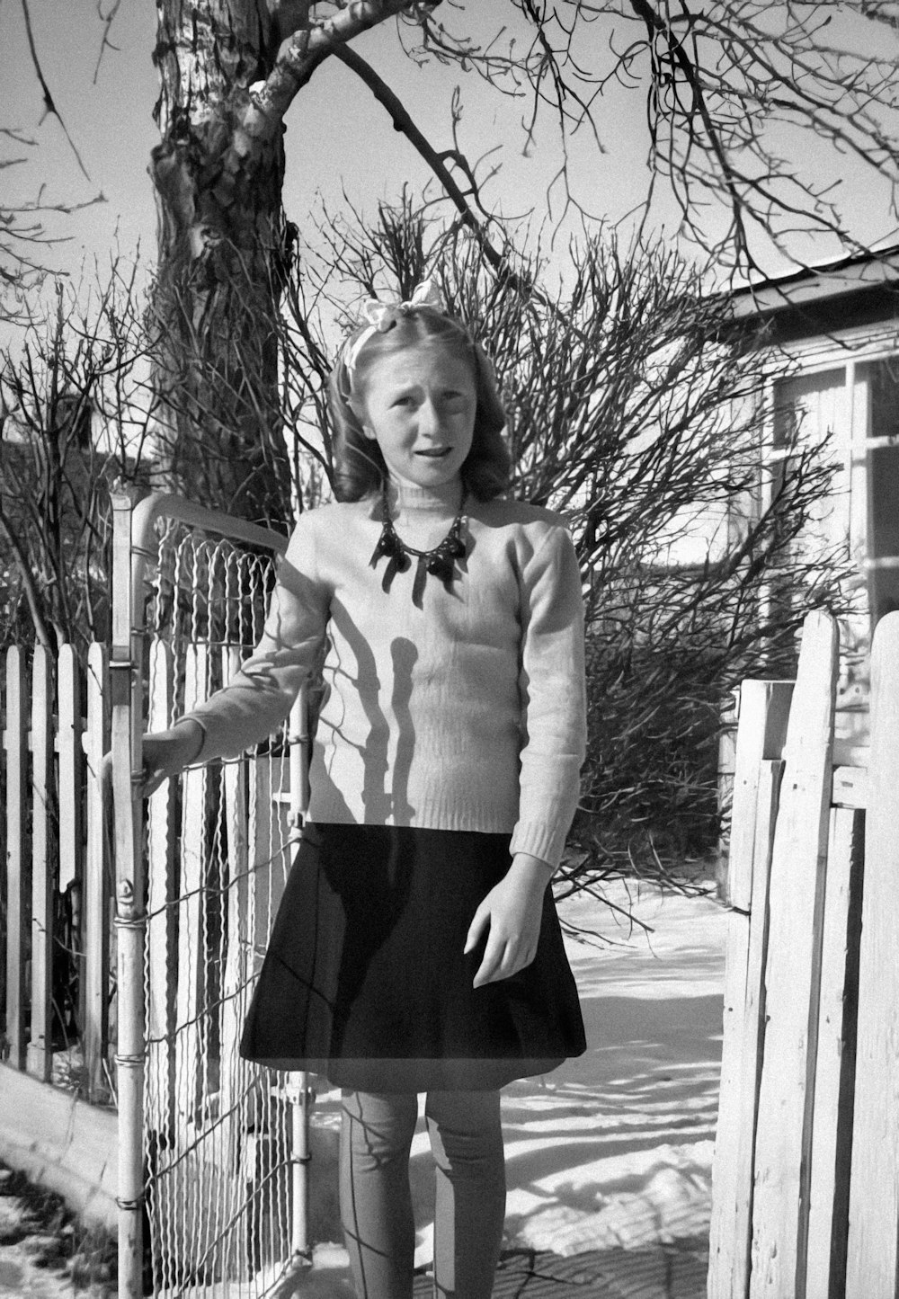 a woman standing in front of a fence