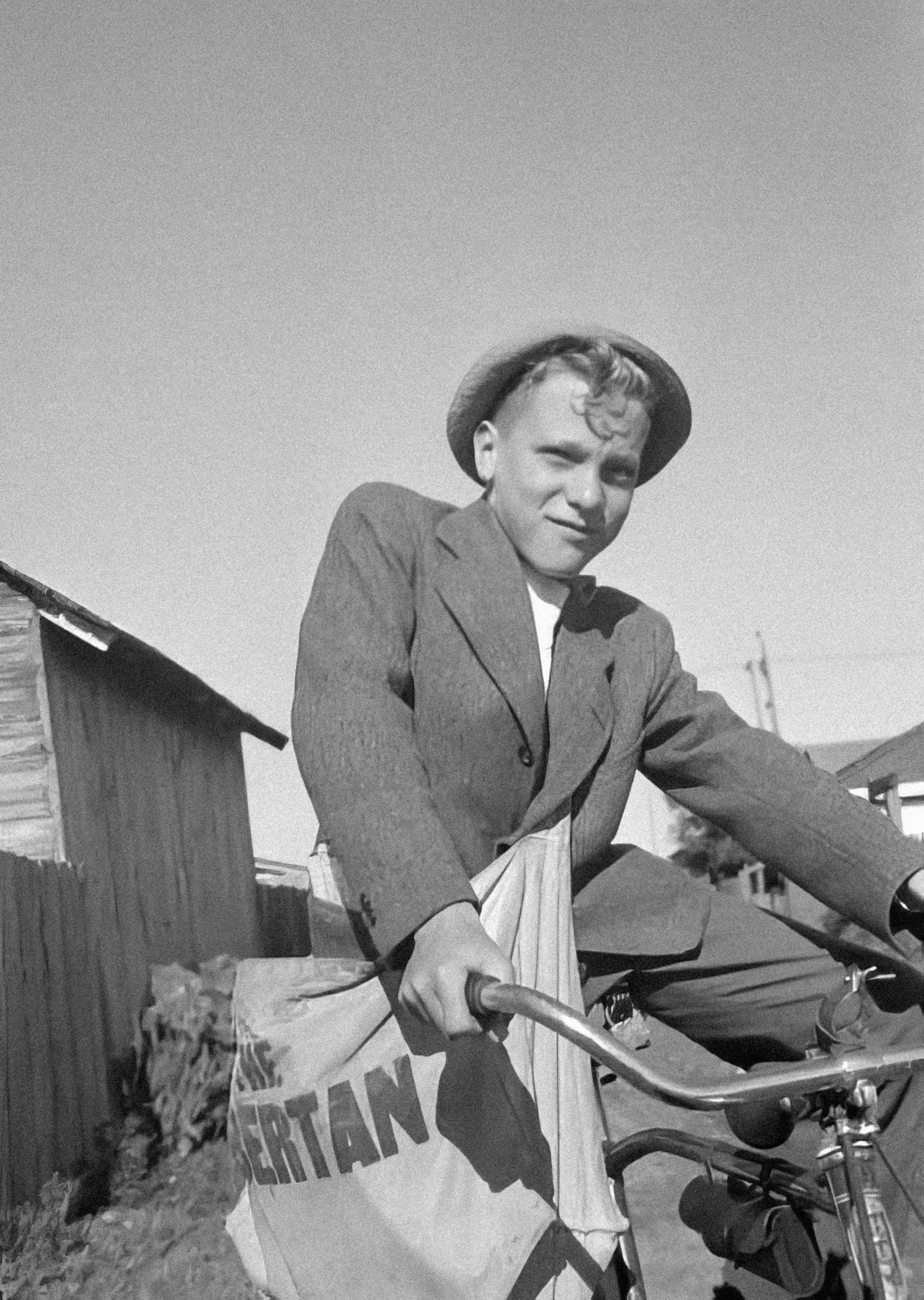 a black and white photo of a man on a bicycle
