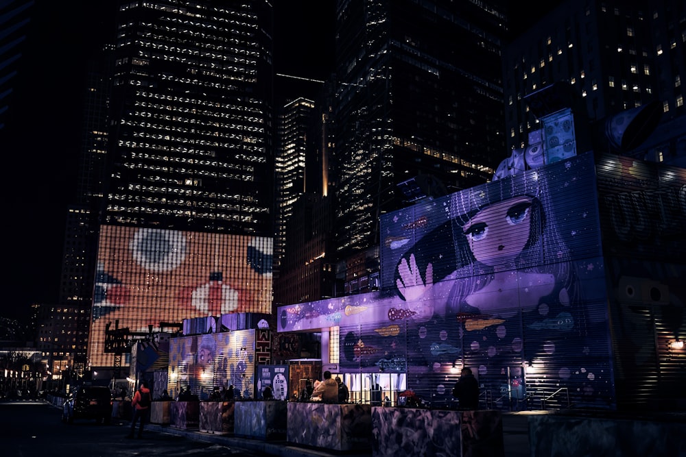 a city street at night with a large advertisement on the side of a building
