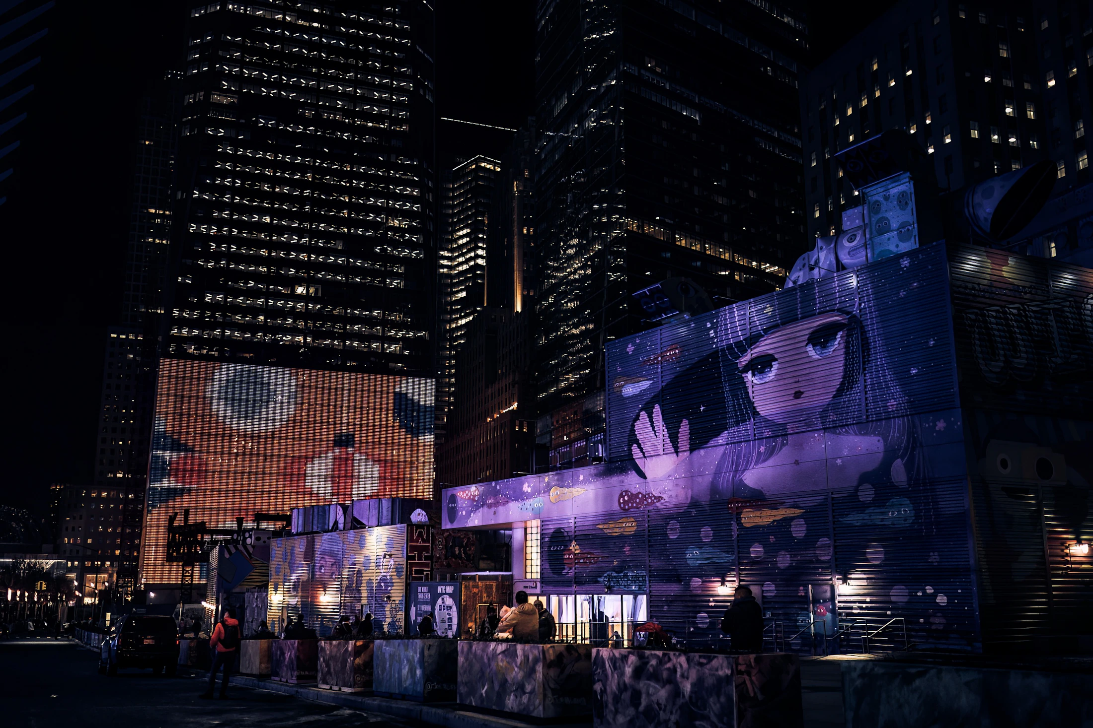 Large digital advertising facade dominating a city streetscape at night