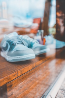 a pair of blue sneakers sitting on top of a wooden bench