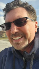 A warm photo of Andres Lopez smiling outside a cozy neighborhood home.