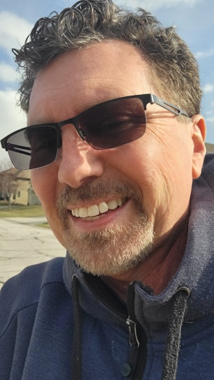 Denny Humphrey smiling warmly outside a charming Houston neighborhood home.