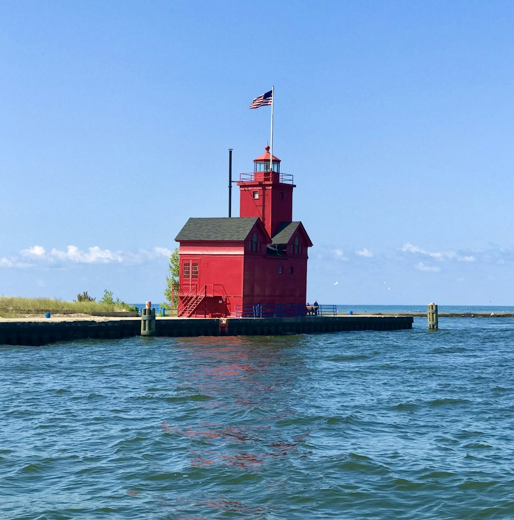 a red lighthouse with a flag on top of it
