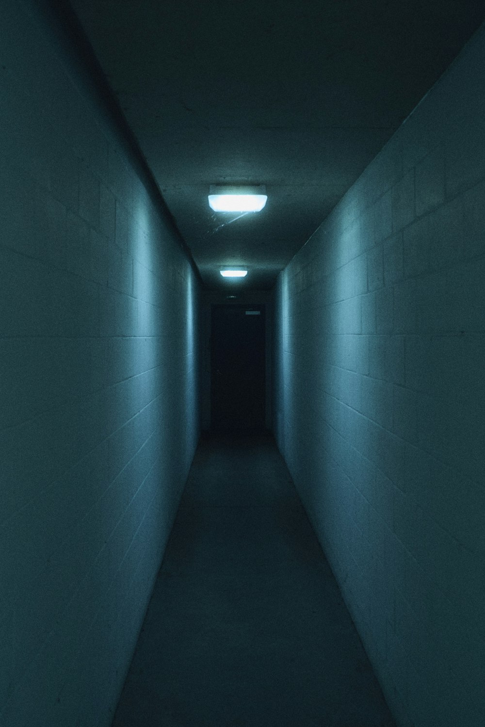 端に明かりのある長く暗い廊下
