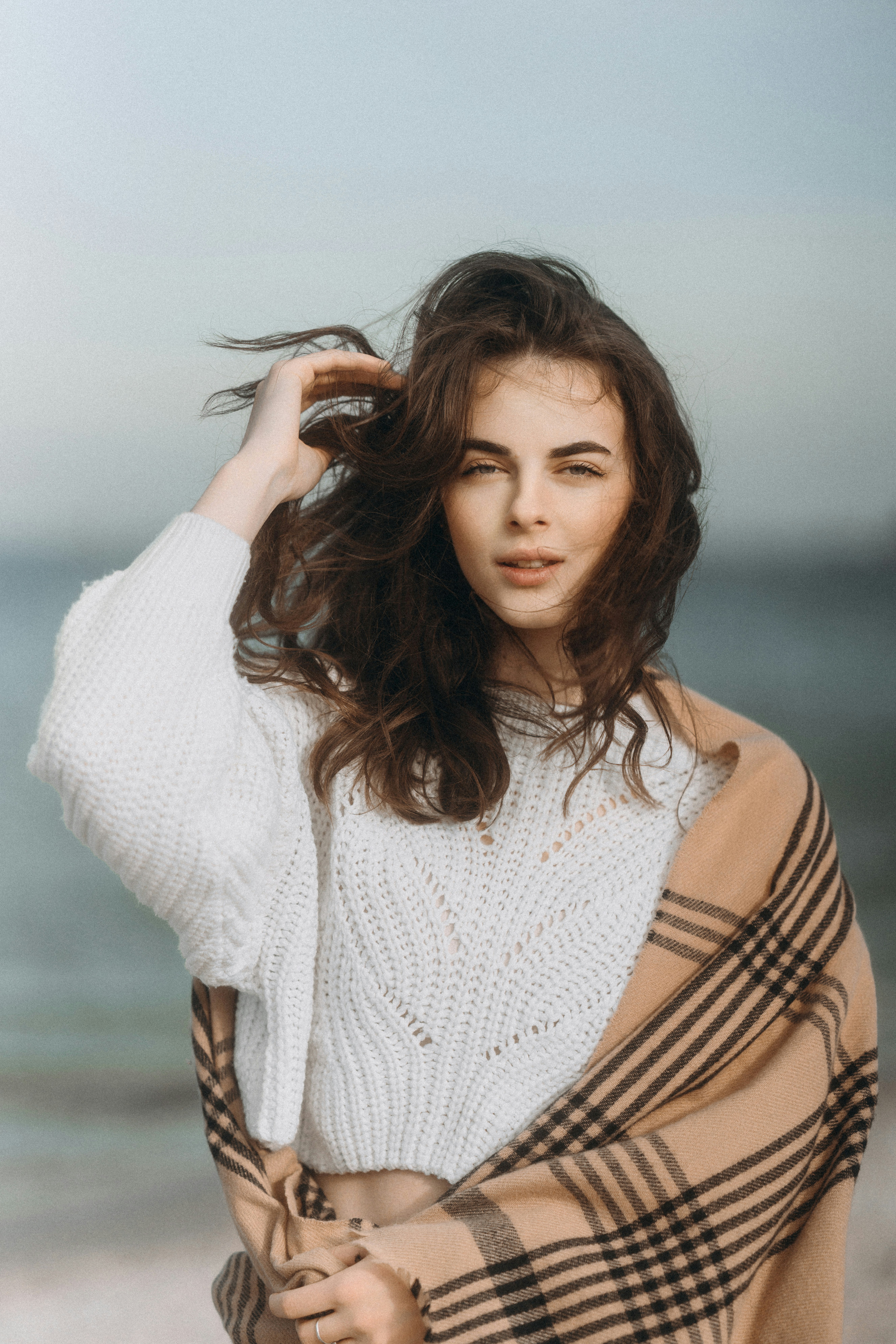 a woman standing on top of a beach covered in a blanket