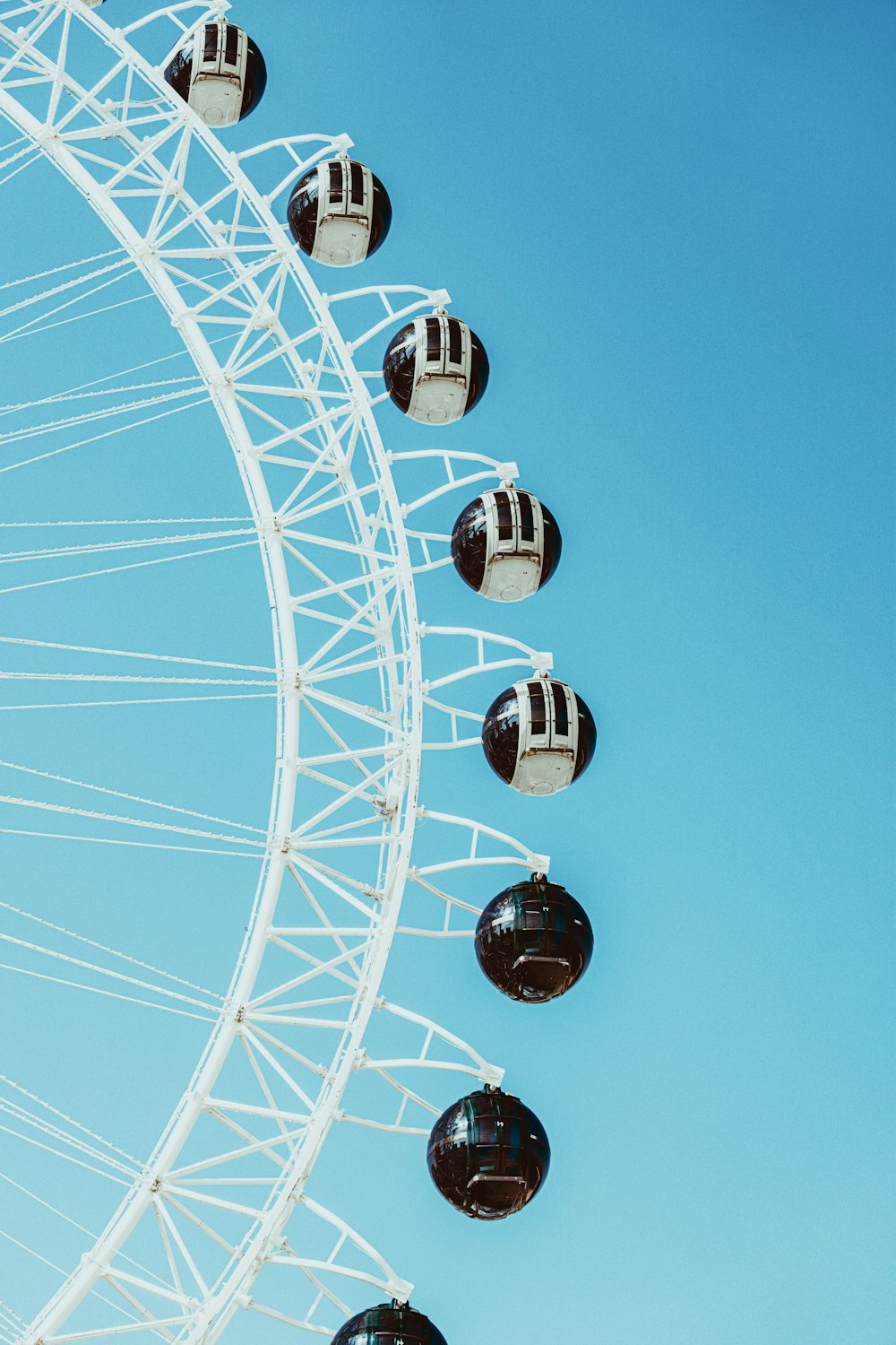 a large white ferris wheel sitting next to a blue sky