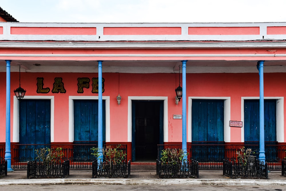 a pink building with blue trim and windows