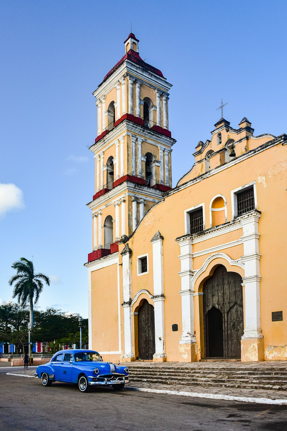 a blue car parked in front of a church