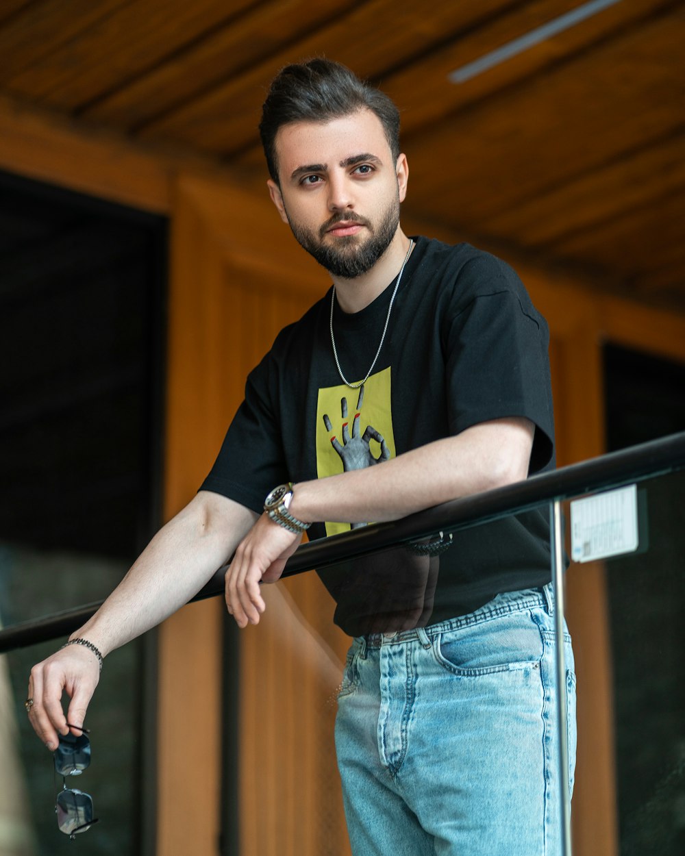 a man with a beard standing on a railing