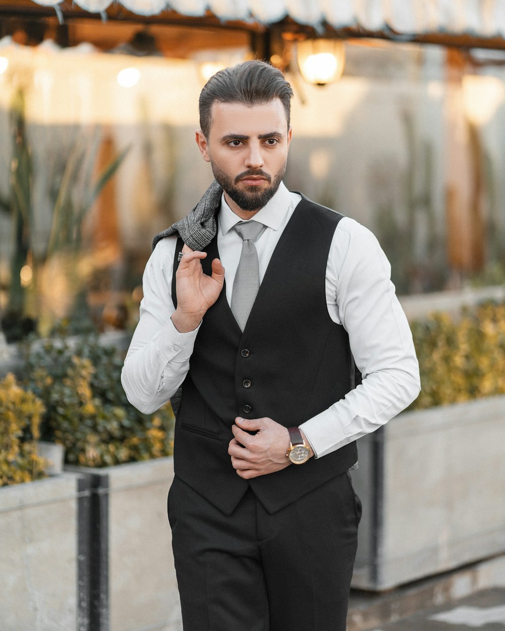 a man in a black vest and tie