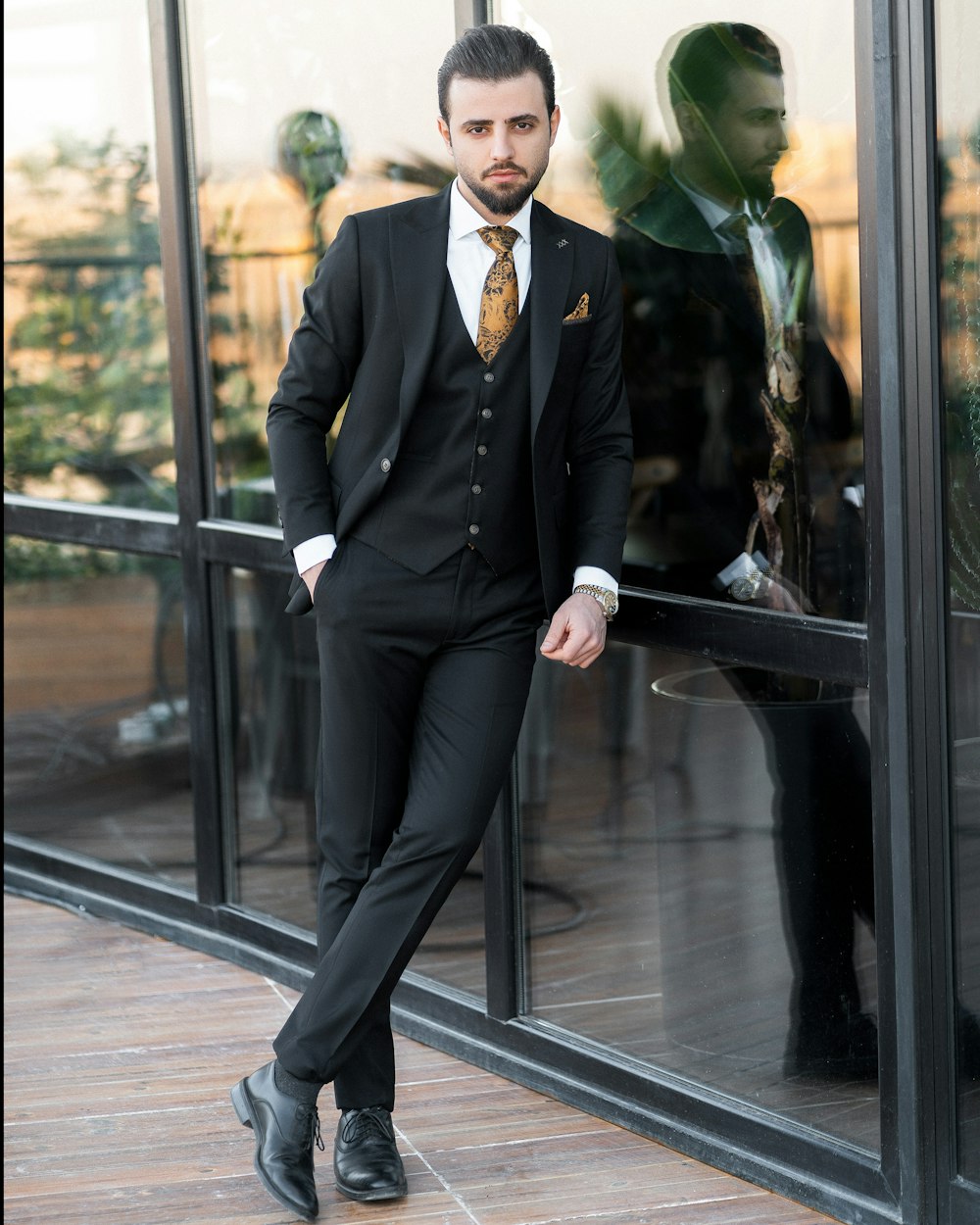 a man in a suit standing in front of a window