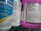 Several bottles of cleaning products are arranged close together on a shelf. Labels on the bottles provide information about the contents, warnings, and usage instructions. The prominent colors are blue and purple, with detailed text visible on the labels.