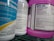 Several bottles of cleaning products are arranged close together on a shelf. Labels on the bottles provide information about the contents, warnings, and usage instructions. The prominent colors are blue and purple, with detailed text visible on the labels.