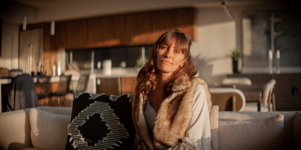 a woman sitting on a couch holding a pillow