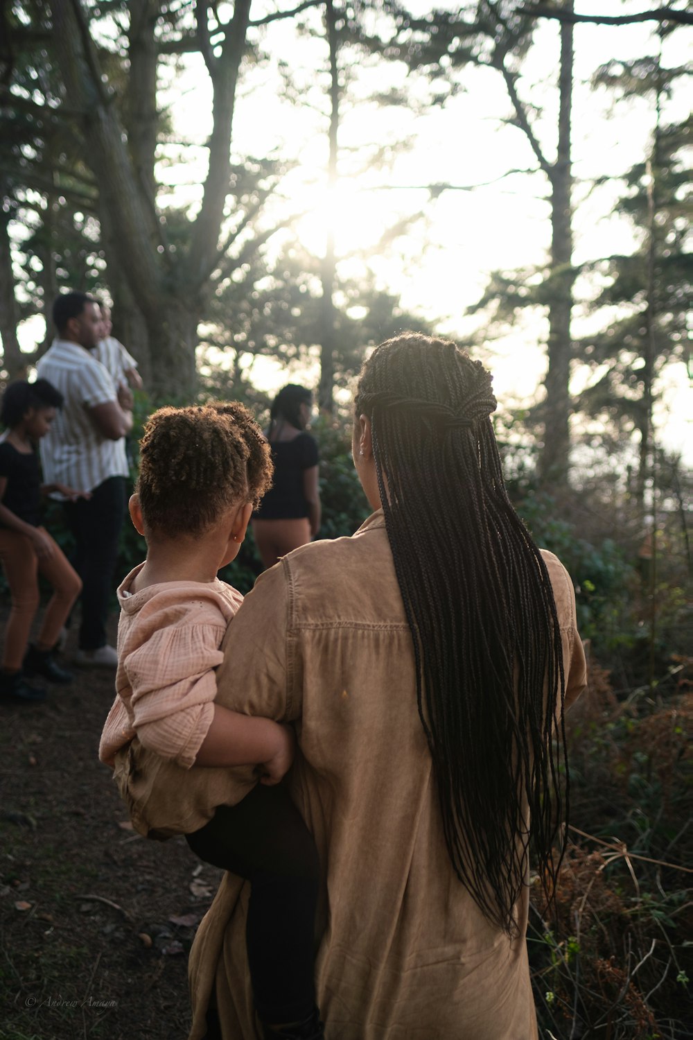 a woman holding a child in a forest