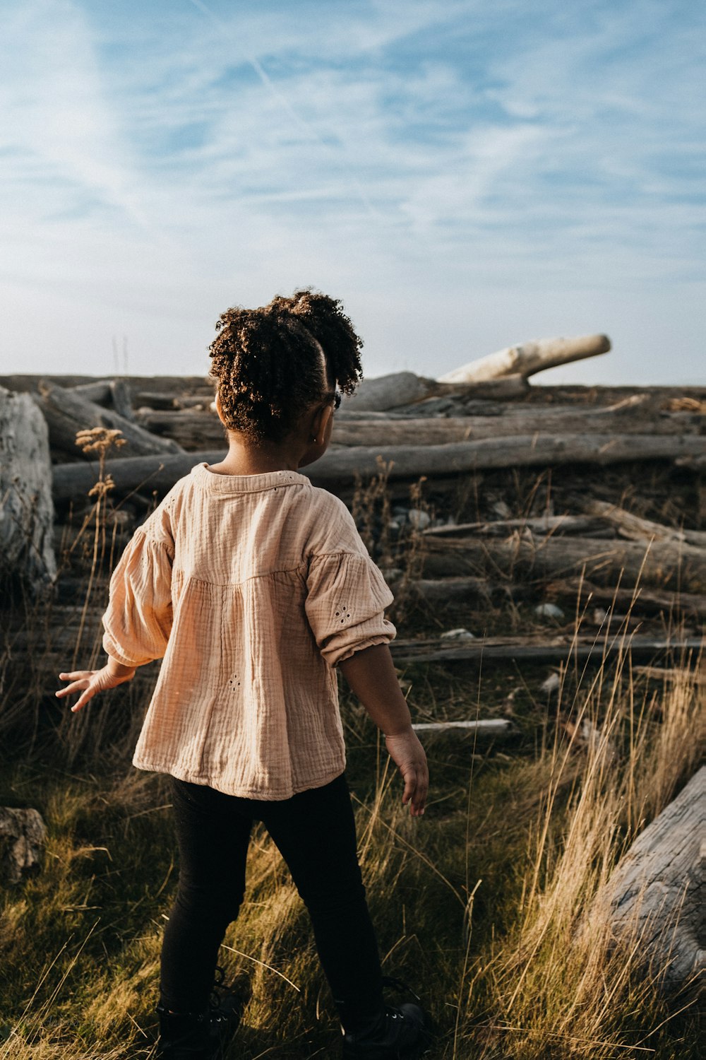 a little girl that is standing in the grass