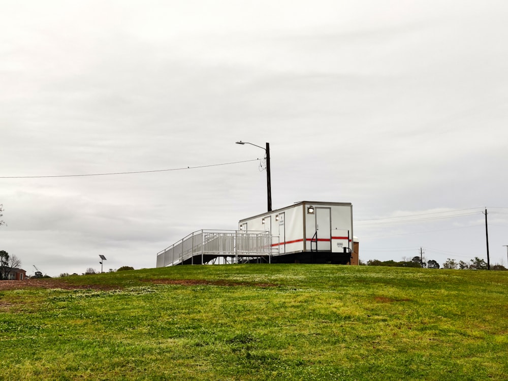 a house on a hill with a red and white railing