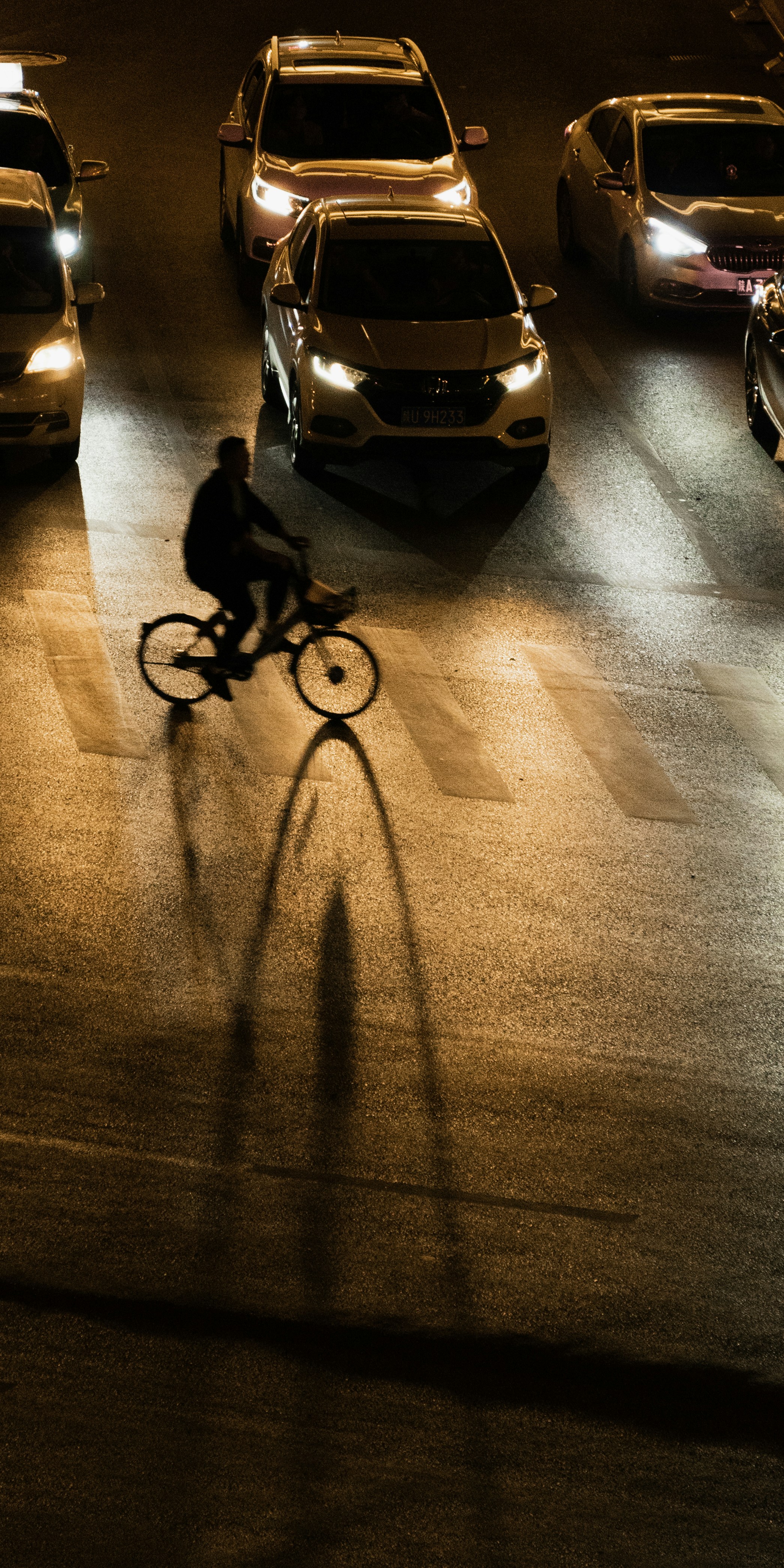a person riding a bike down a street at night