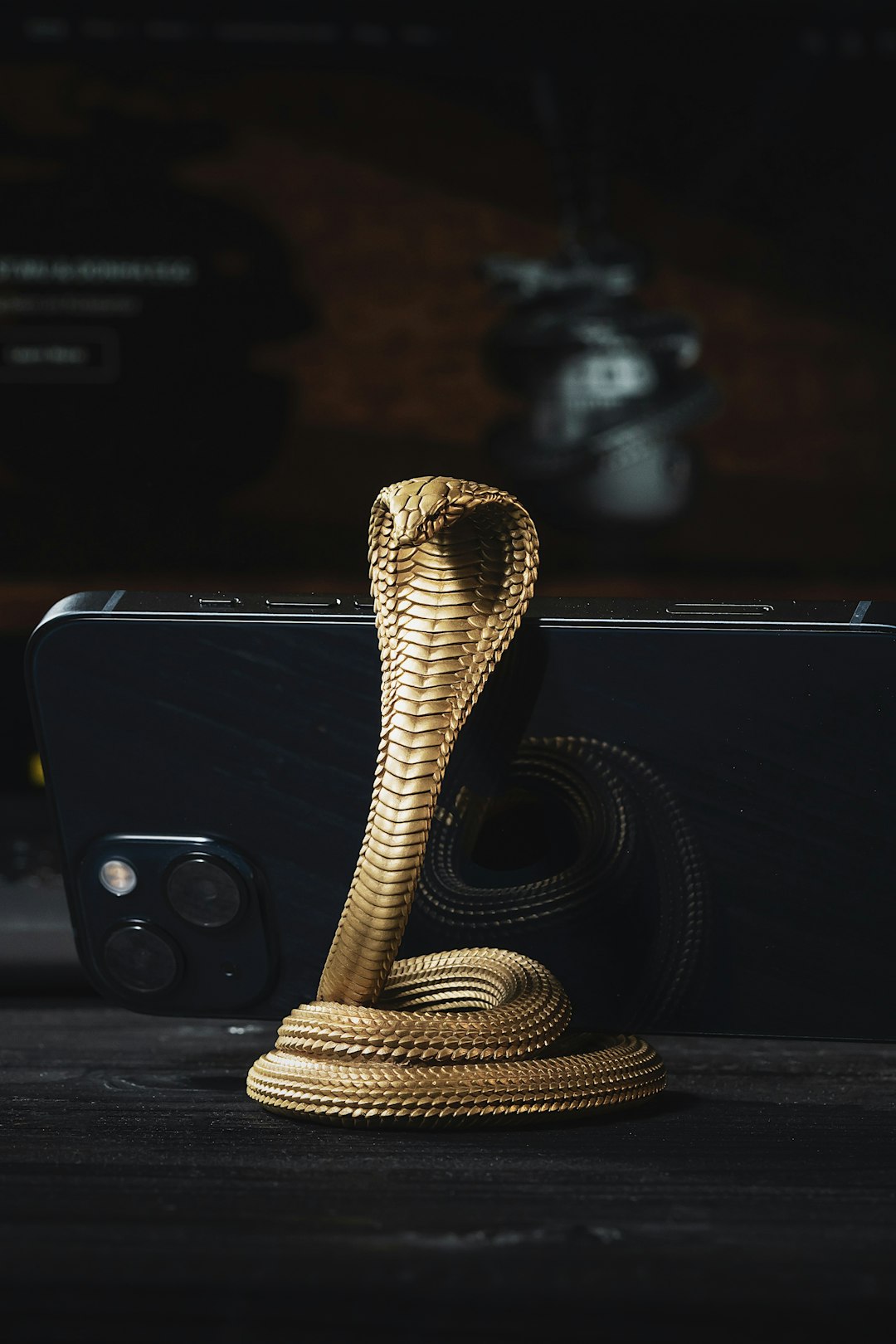 a phone with a gold snake on top of it