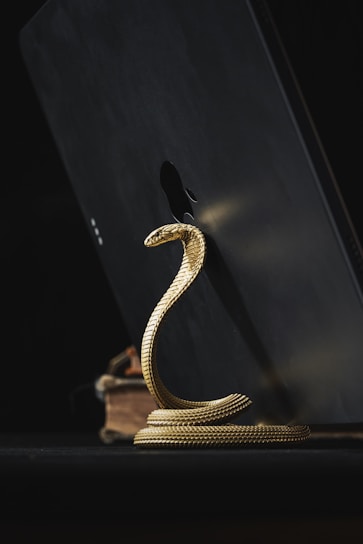 a golden snake statue sitting on top of a table