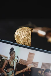 A smiling woman viewing a live video demo of a necklace on her smartphone.
