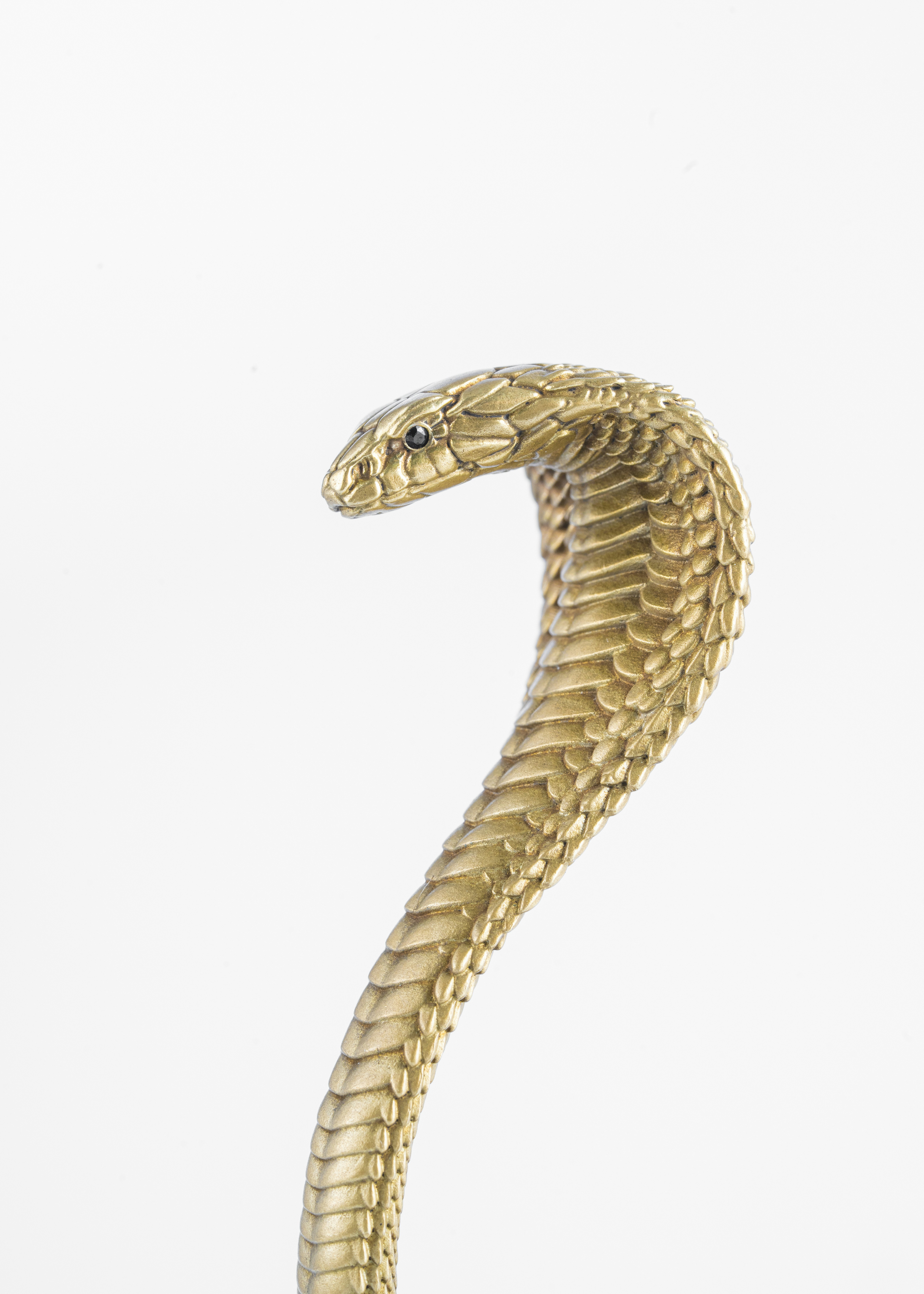 A gold snake statue sitting on top of a table photo Free Cobra Image