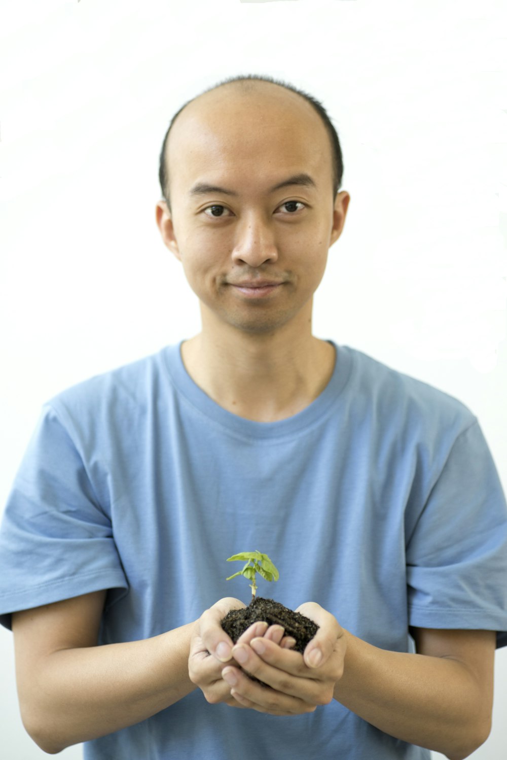 a man holding a plant in his hands