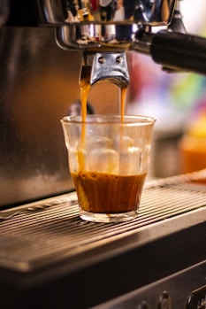 a cup of coffee being filled with liquid