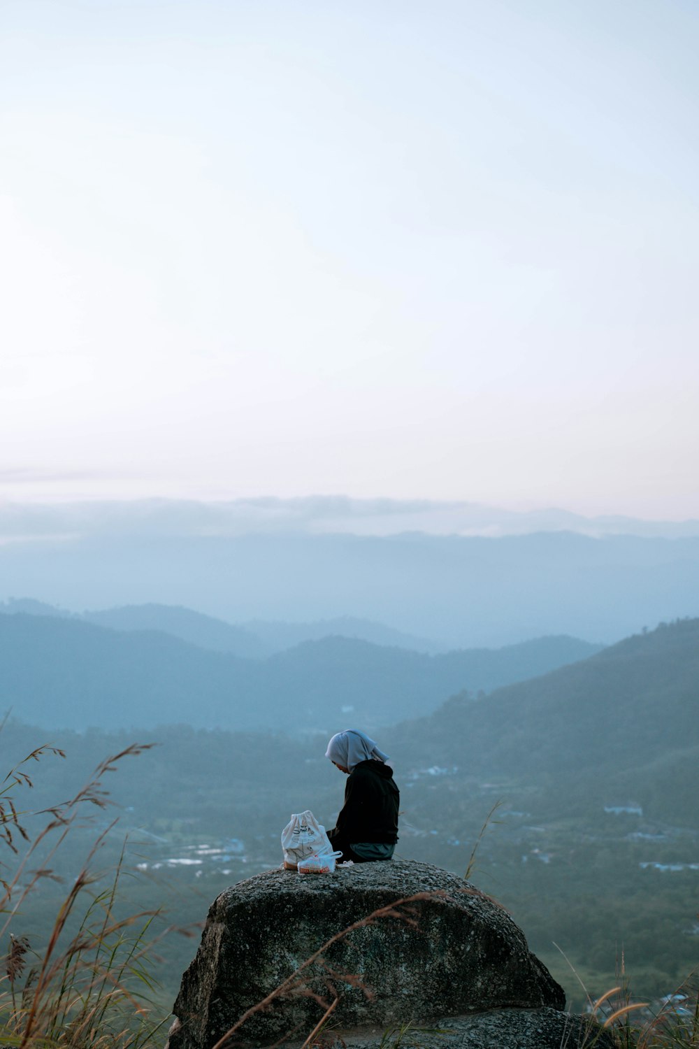 a person sitting on top of a large rock