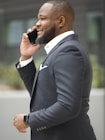 a man in a suit talking on a cell phone