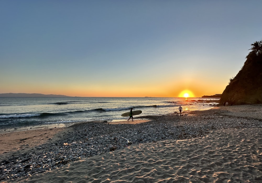 a person holding a surfboard on a beach