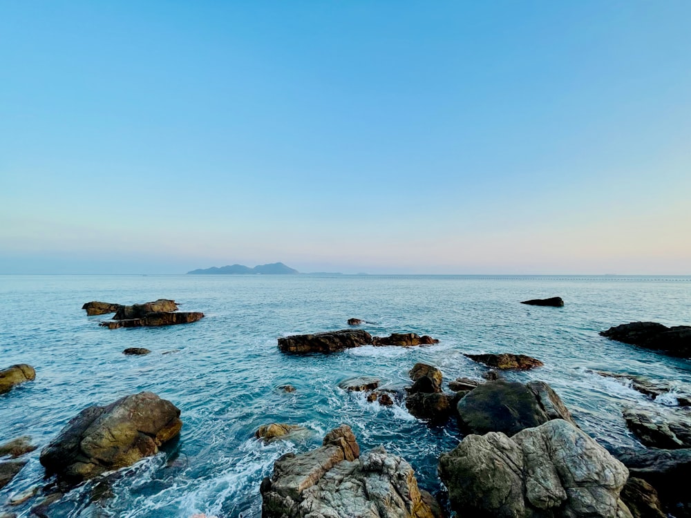 a body of water with rocks in the foreground