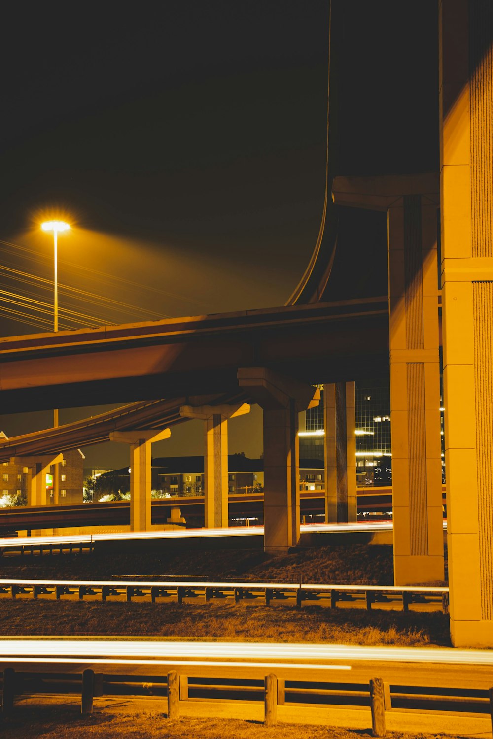 a view of a highway at night with a bridge in the background