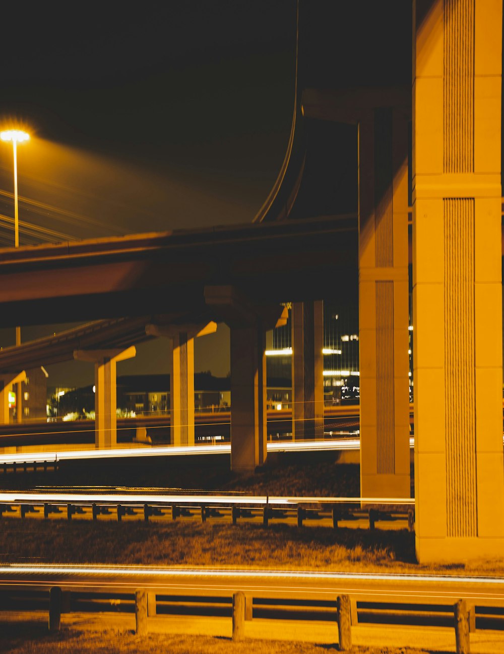 a view of a highway at night with a bridge in the background