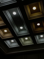 Close-up of a stylish ceiling with recessed lighting and textured panels.
