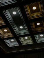 A freshly installed drop ceiling with clean lines and perfect alignment under soft blue lighting.