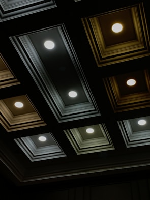 Close-up of a stylish ceiling with recessed lighting and textured panels.