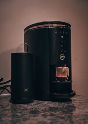 A sleek smart coffee maker placed on a modern kitchen counter.
