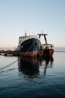 two large ships are docked in the water