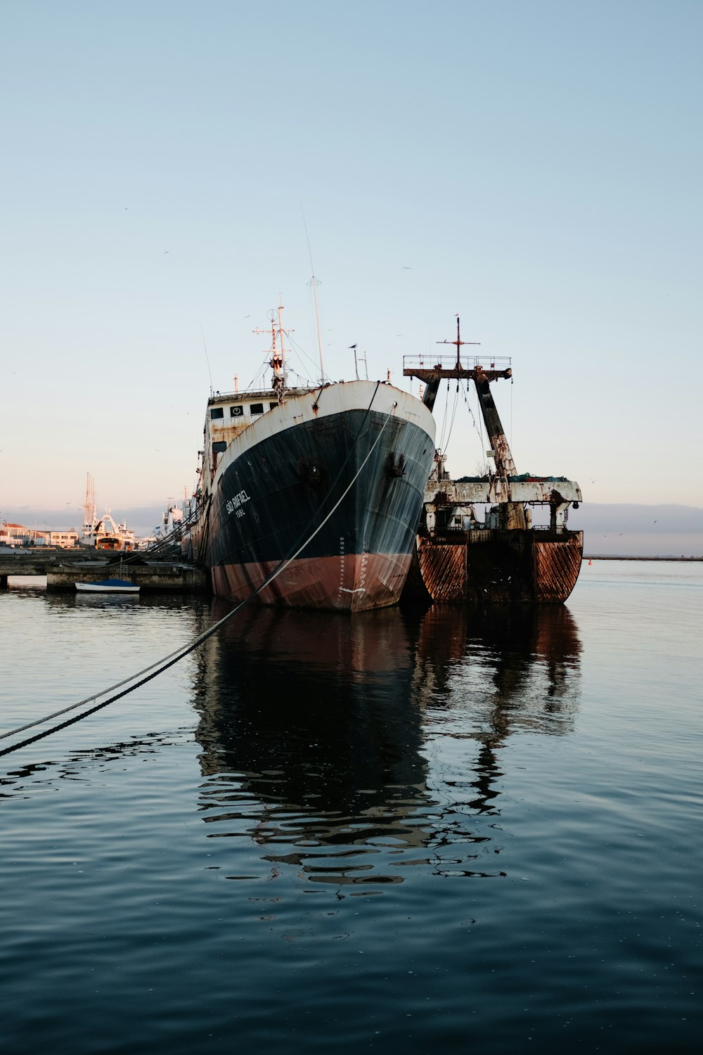 two large ships are docked in the water