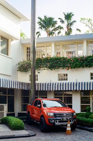 Bright red RapidTrust Auto truck parked in front of the Miami Beach office, ready for service.