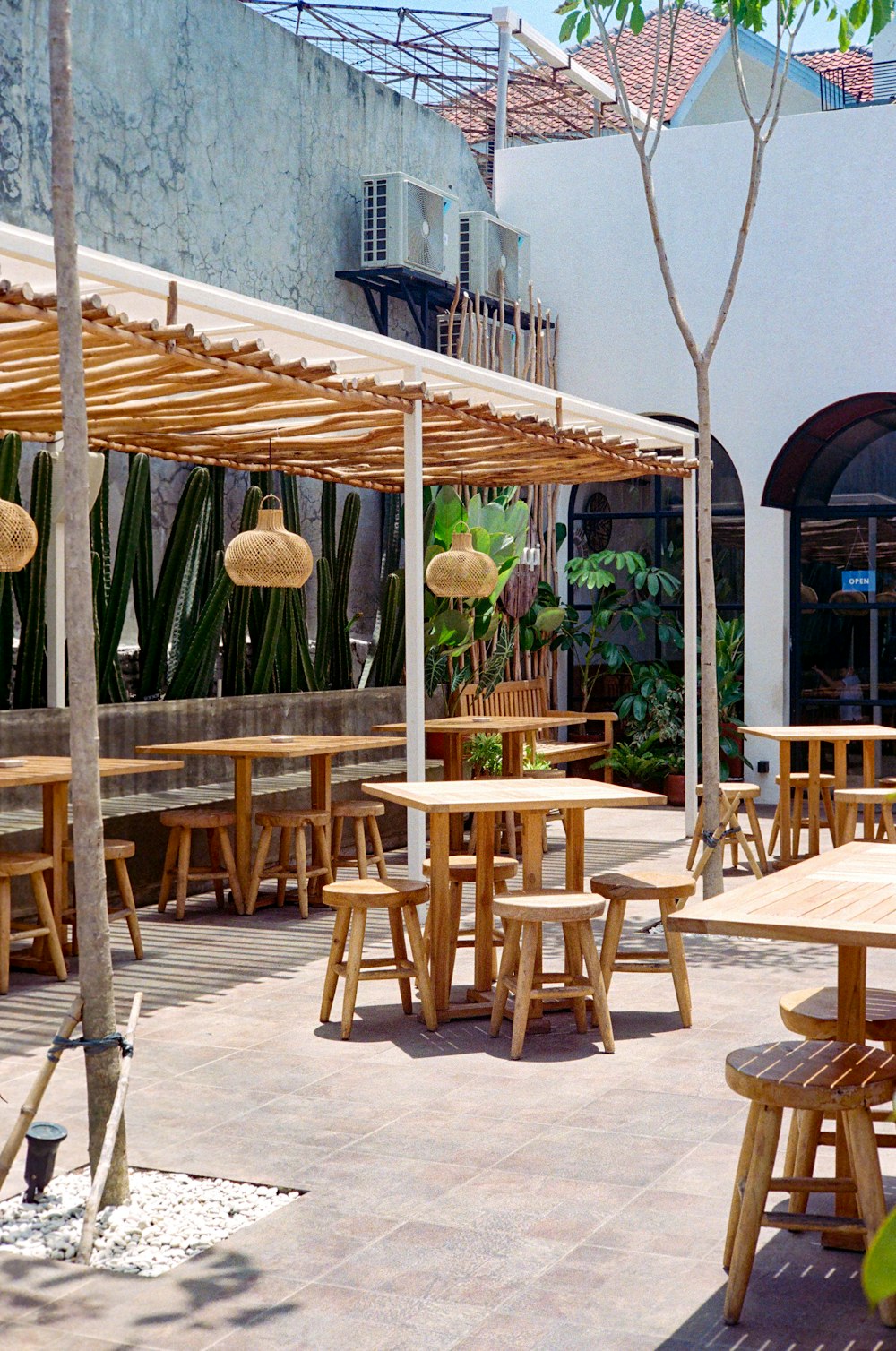 a patio area with tables and chairs and umbrellas