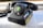 A vintage rotary dial telephone with a sticker featuring a stylized illustration of a woman's face on the dial. The phone is black and appears to be resting on a magazine or newspaper. There are additional stickers on the phone, including one that reads 'make stickers' and another with the word 'KINETIC' in yellow. The phone cord is coiled and extends to the left.