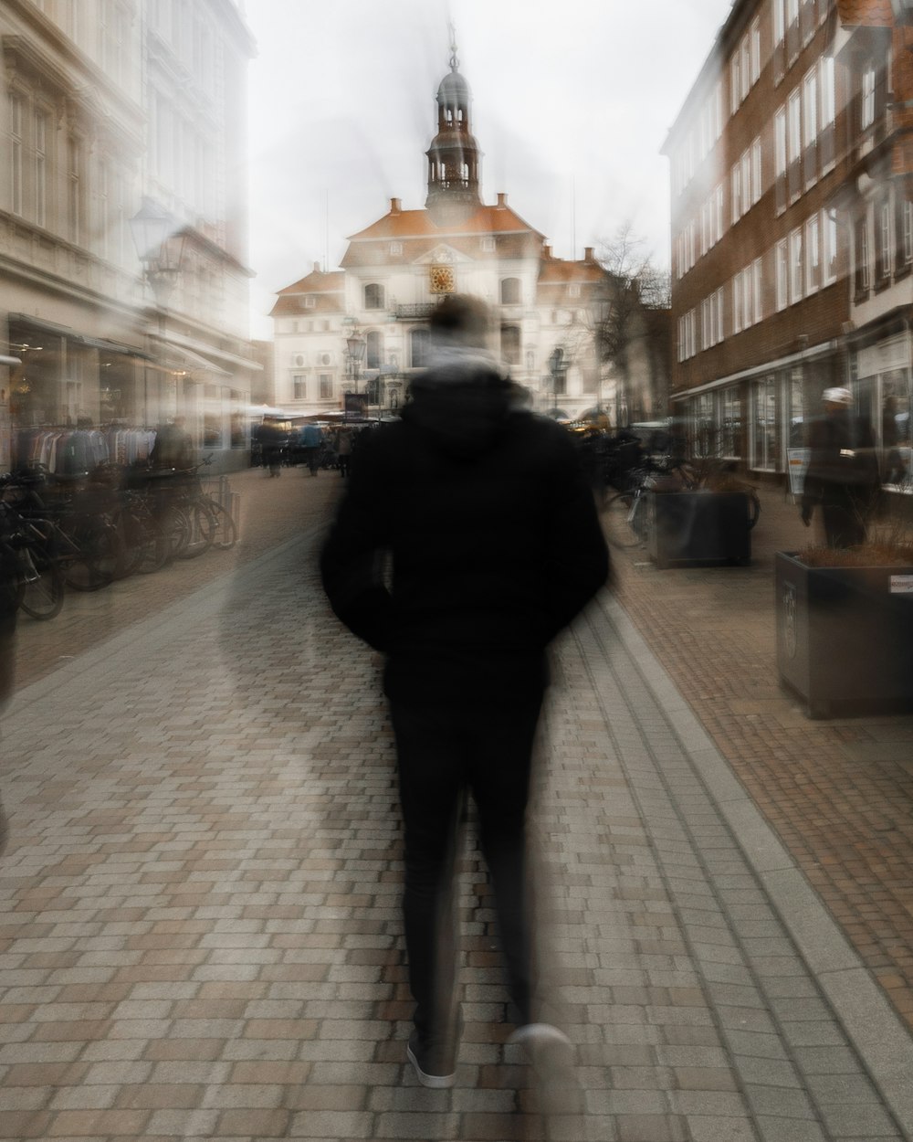 a blurry photo of a person walking down a street