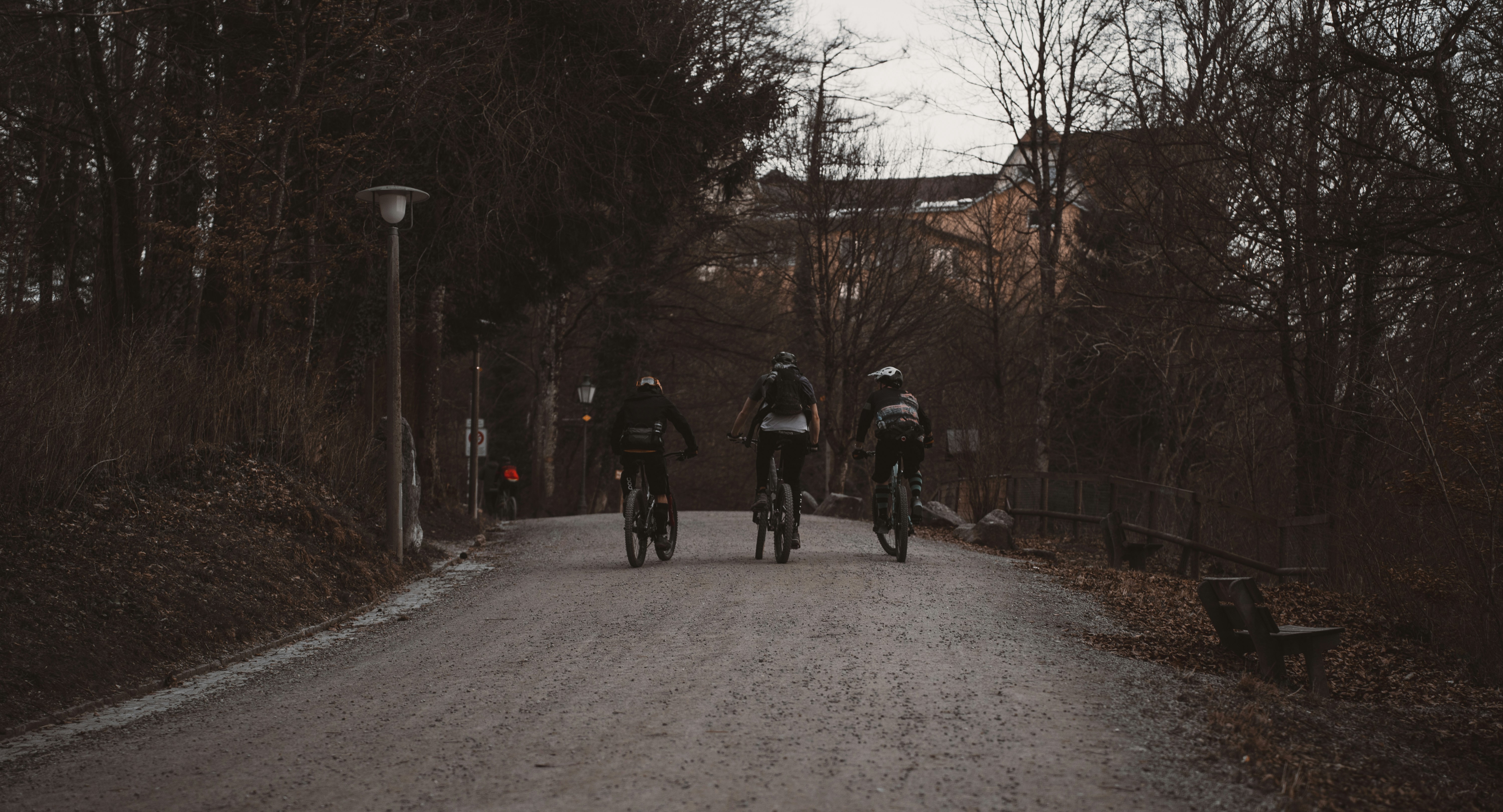 a group of people riding bikes down a dirt road